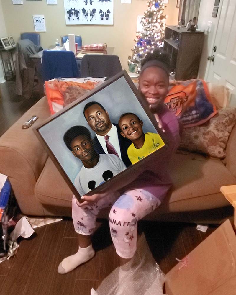 Smiling girl holding framed portrait of three people.