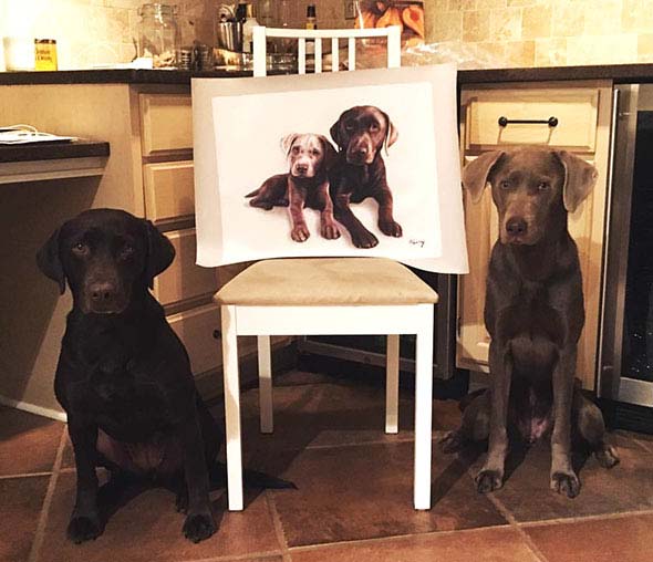 2 cute dogs standing near their oil portrait