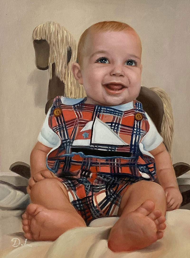 Smiling baby in plaid overalls sitting on a rocking horse.