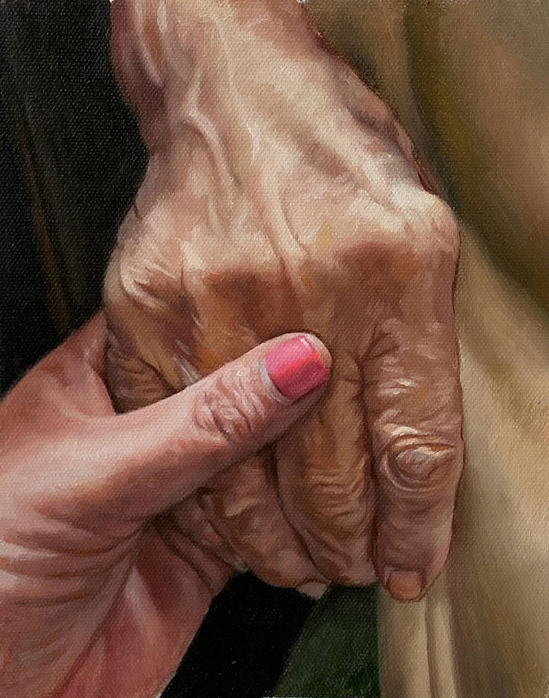 Two hands clasped together, one young, one elderly.
