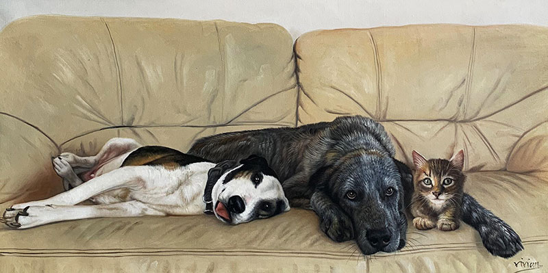 Painting of two dogs and a kitten relaxing on a beige couch.