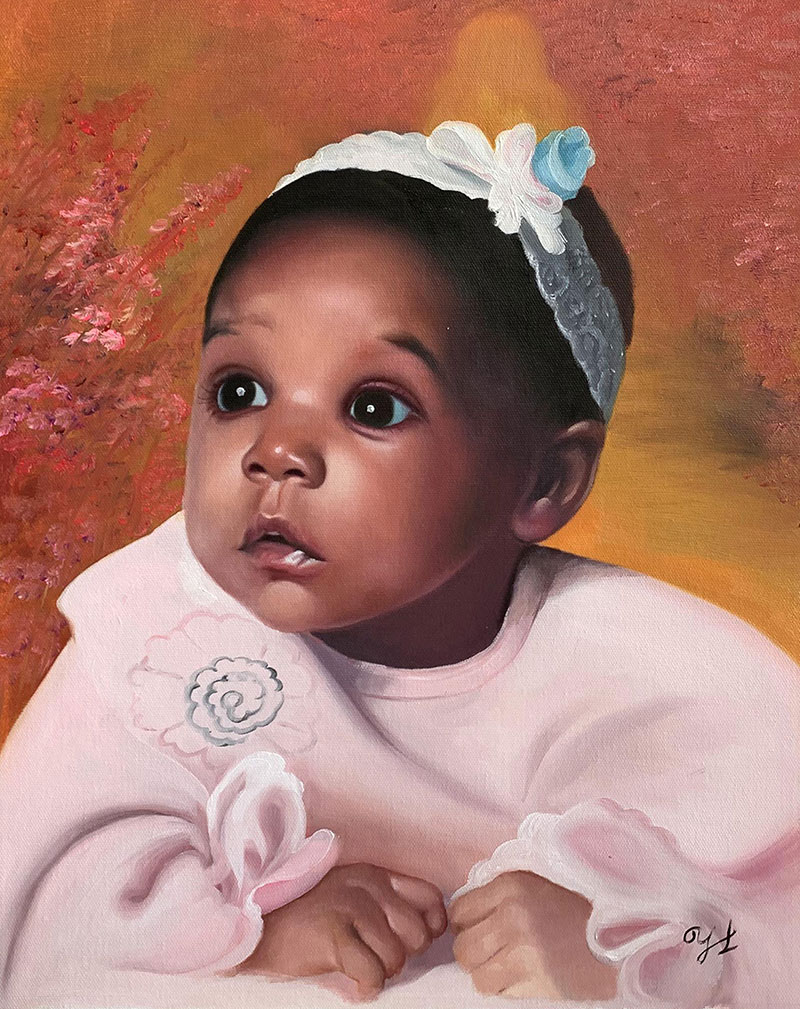 Portrait of a baby girl in a pink outfit wearing a headband.