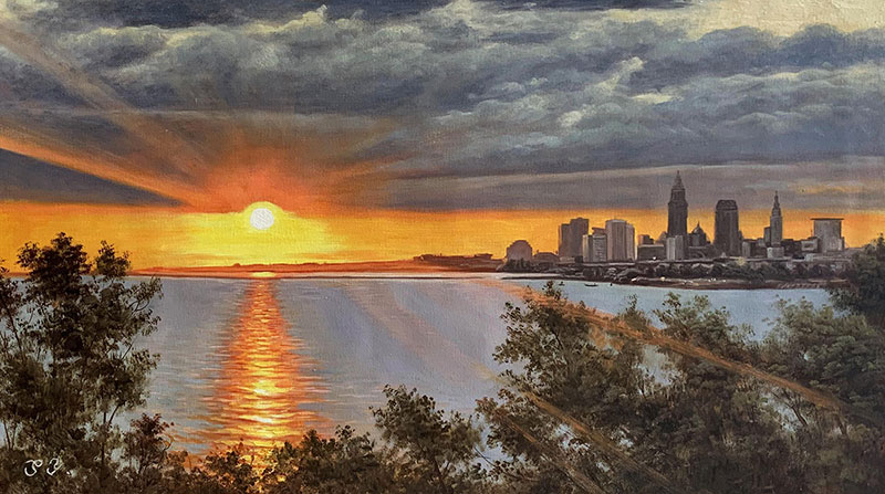 Sunset over city skyline reflected in water.