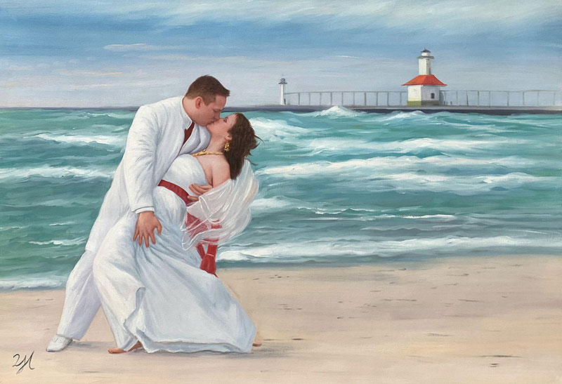 Bride and groom kissing on beach with lighthouse in background.