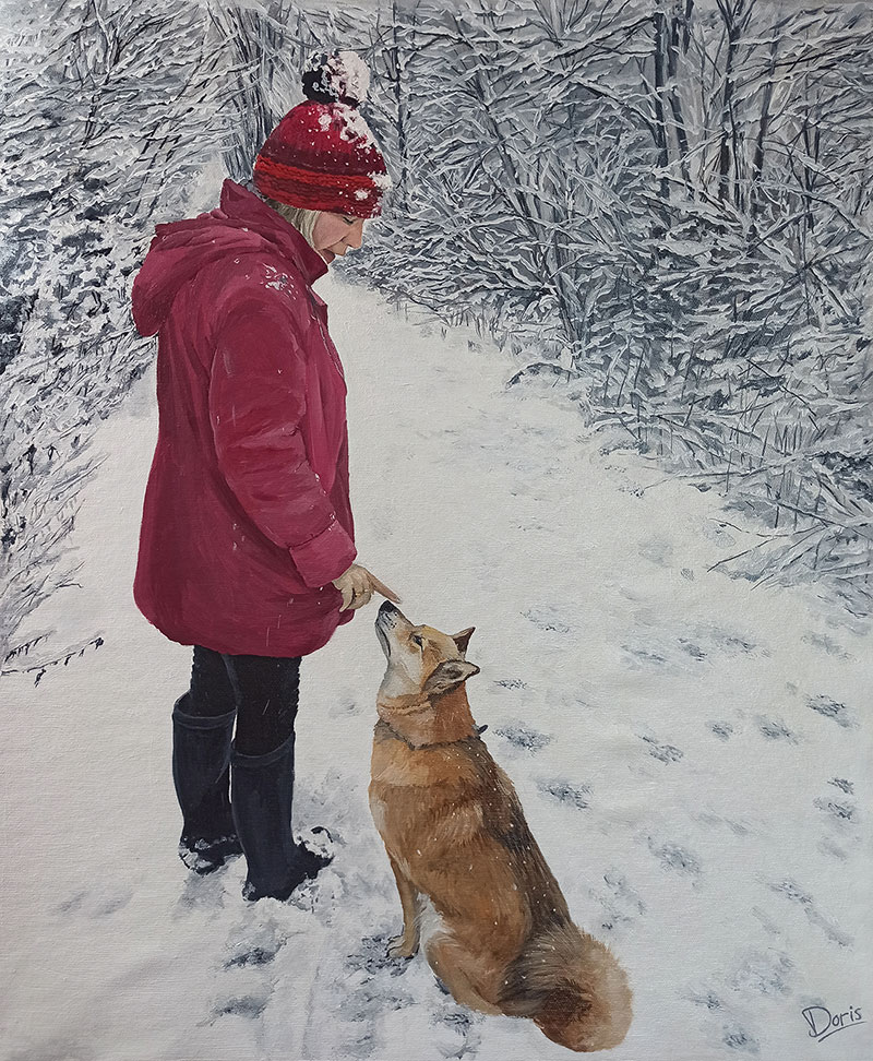 Woman in red coat and snow-covered hat interacting with a dog in a snowy landscape.