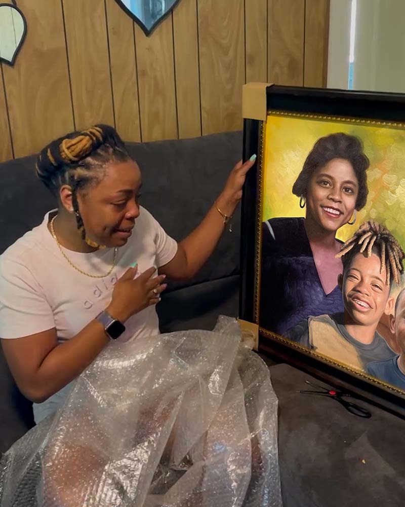 Woman emotionally unveiling a framed portrait of her mother and child.