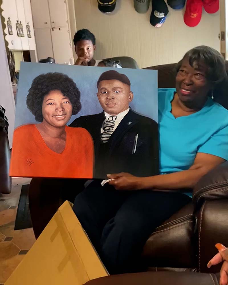 Woman holding a painted portrait of a couple.