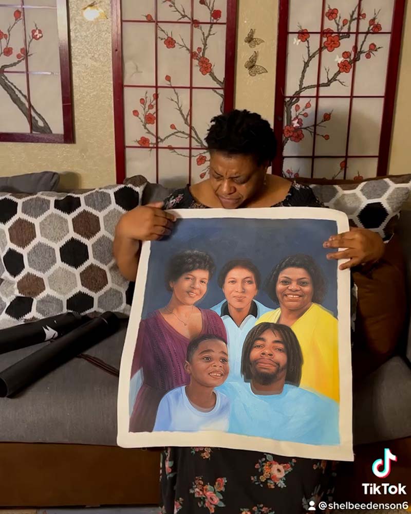 Woman holding a large painted family portrait.