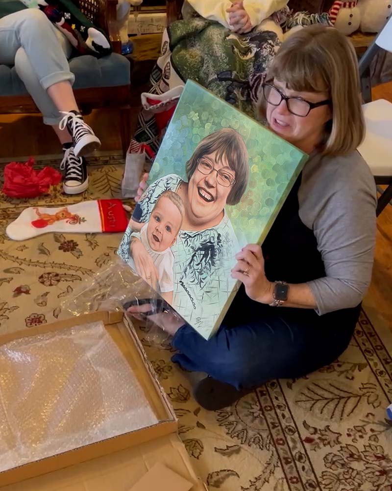 Woman unboxing a painted portrait of a woman and baby.