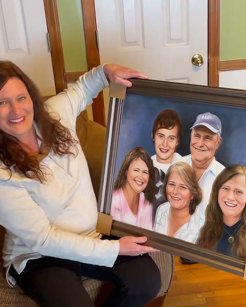 Woman holding framed family portrait.