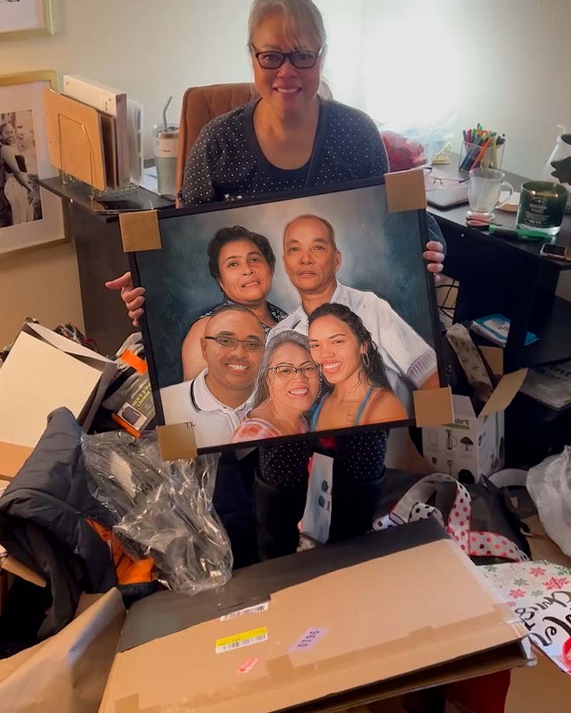 Woman holding framed family portrait amidst boxes