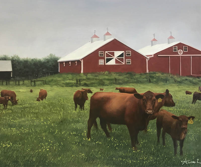 Red barns and brown cows in a green field.