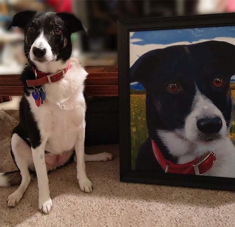Black and white dog sitting next to its painted portrait.