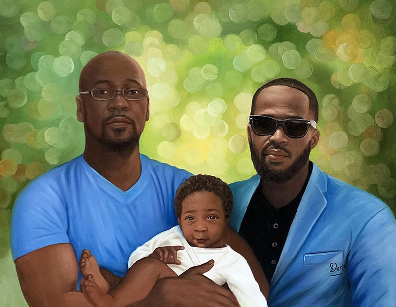 Portrait of two Black men holding their baby.