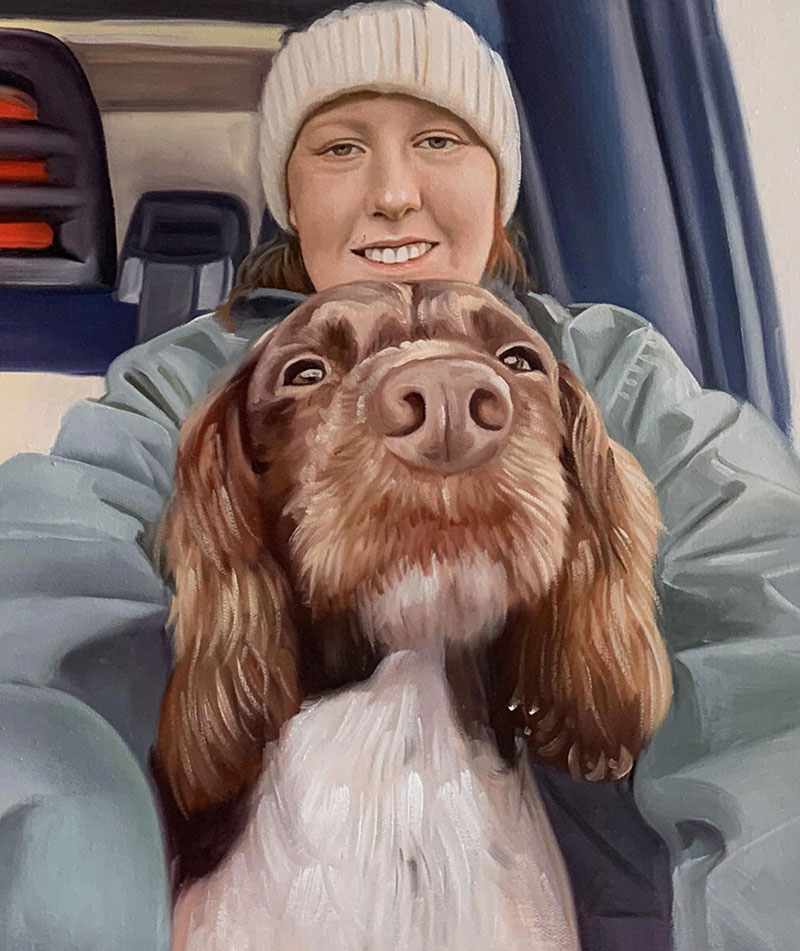 Painting of a woman in a knit hat holding her brown and white spaniel dog.