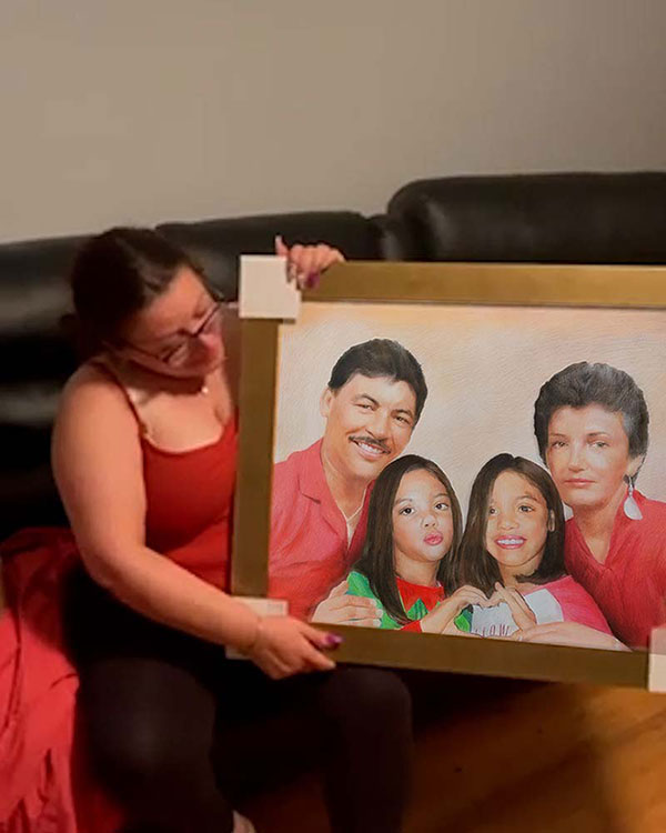 Woman holding framed family portrait.