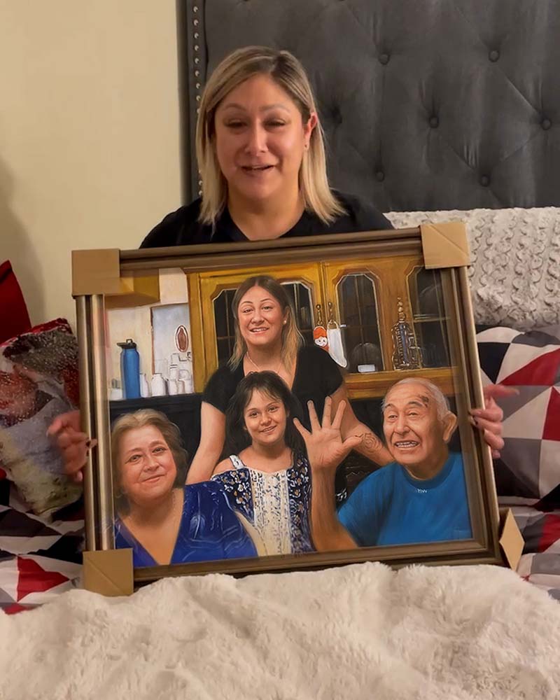 Woman holding framed family portrait.