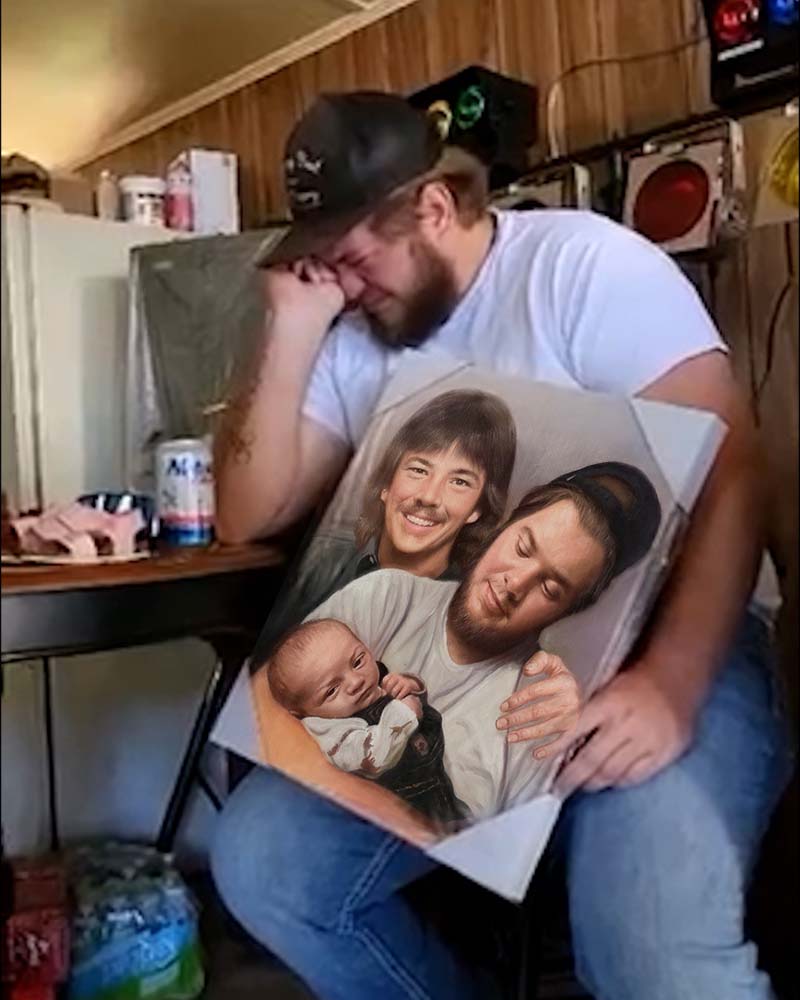 Man crying while holding a painted portrait of two men holding a baby.