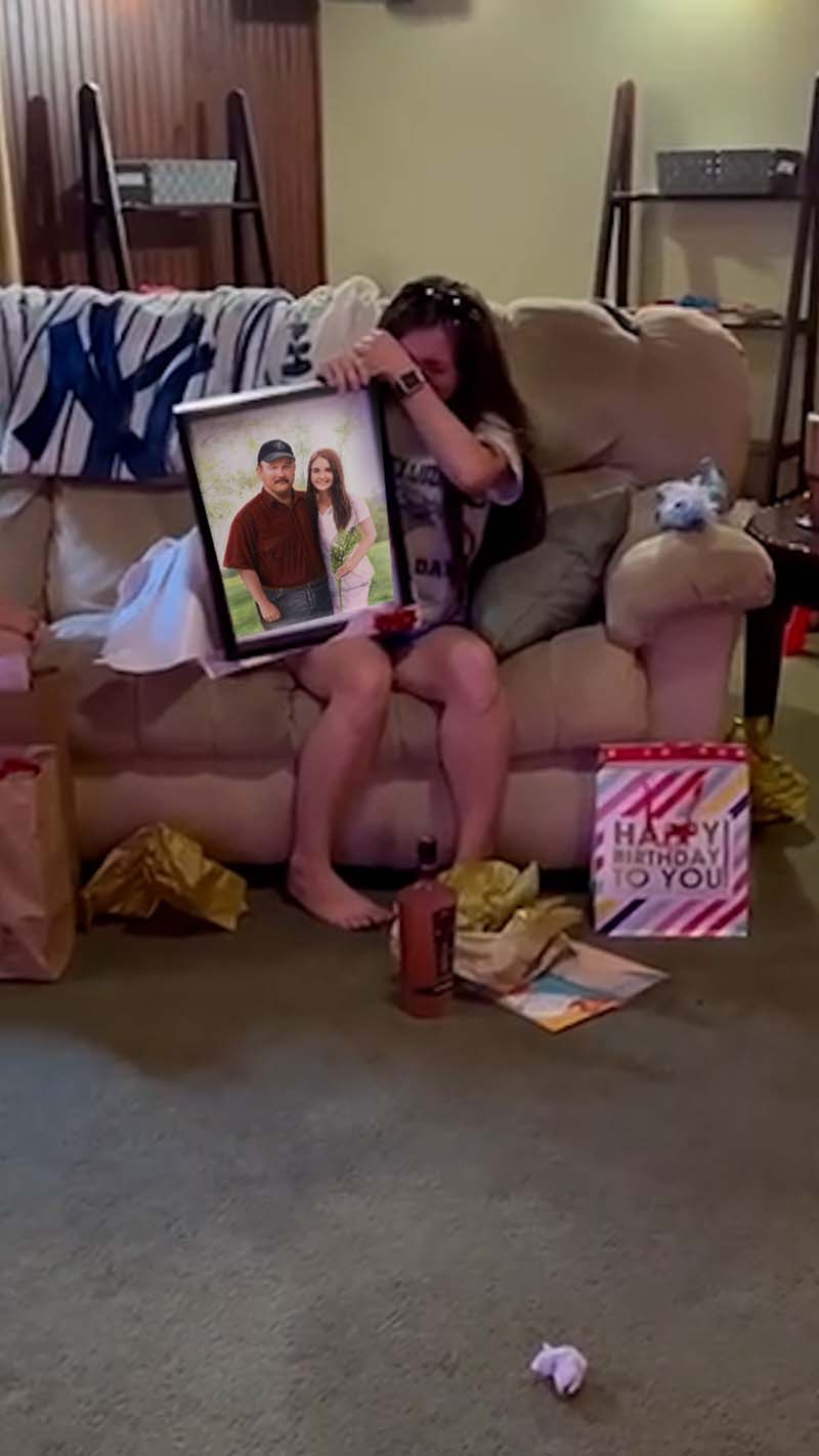 Woman crying while holding a framed photo of a man and woman.