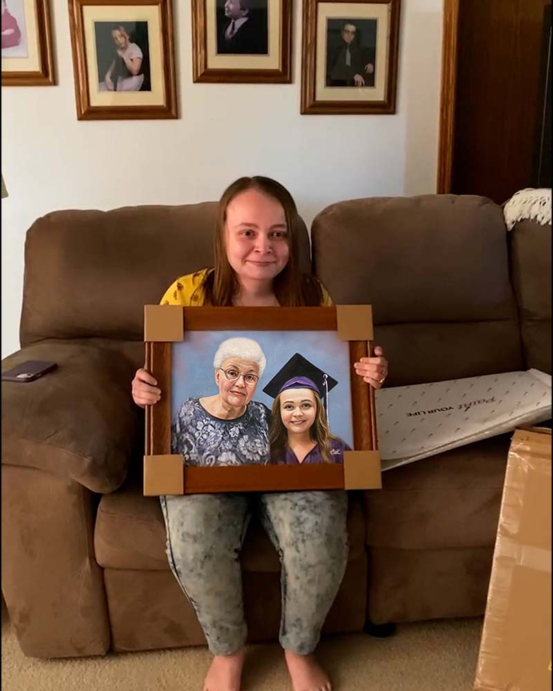 Woman holding framed portrait of older woman and a graduate.