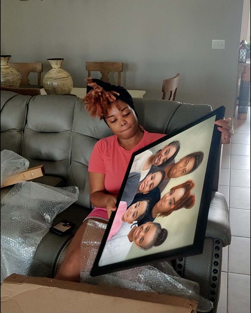 Woman holding framed portrait of family.