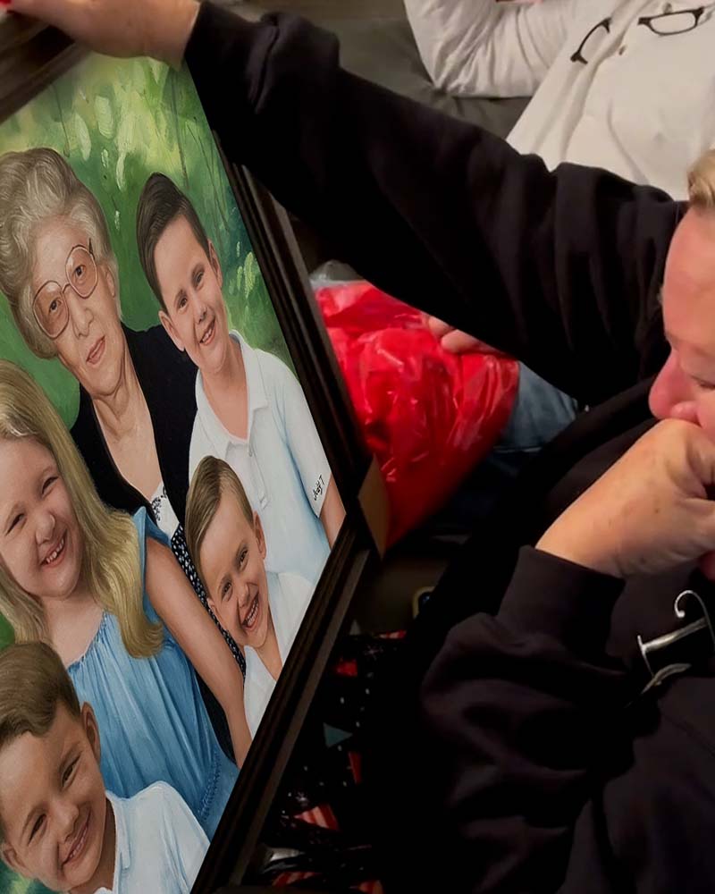 Woman emotionally reacting to a framed family portrait painting.