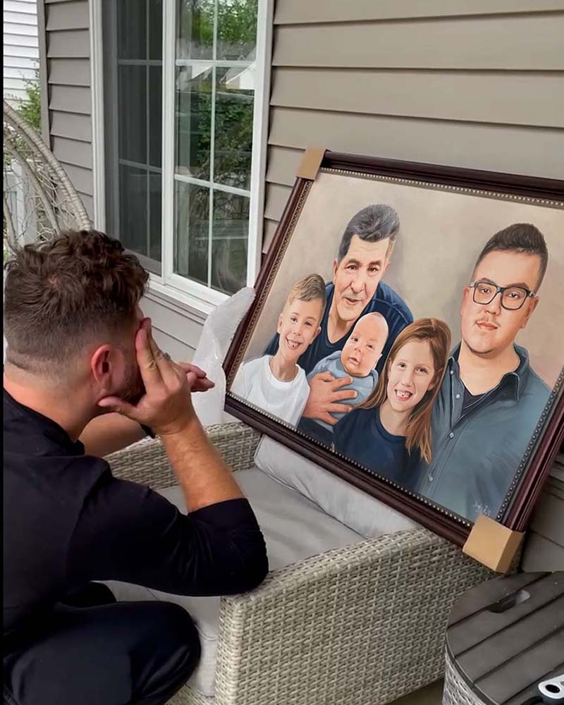 Man looking at framed family portrait