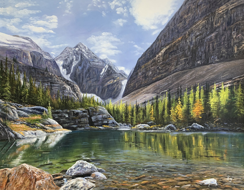 Mountain lake reflecting autumn trees and snow-capped peaks.