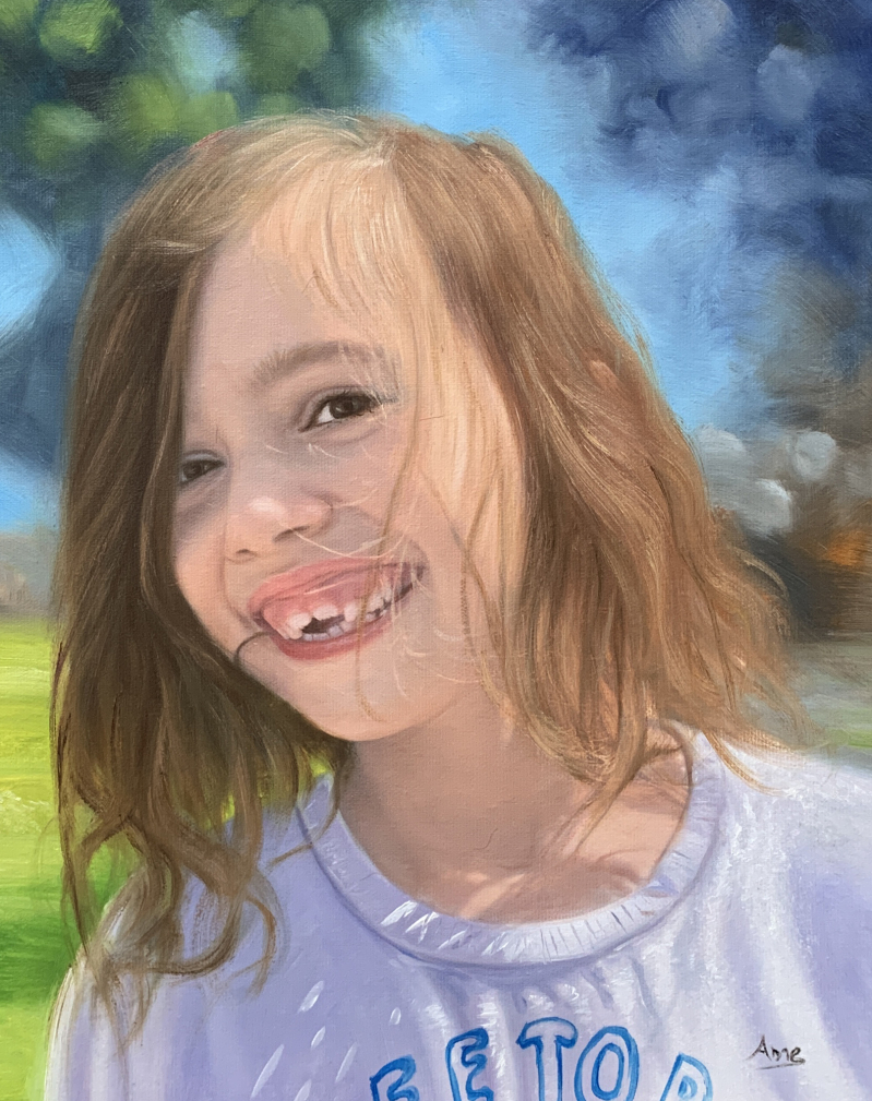 Portrait of a smiling girl with light brown hair wearing a lavender shirt.