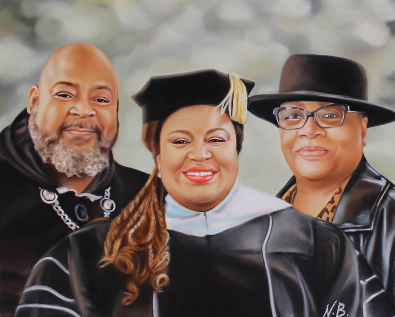 Portrait of a family: a man, a woman in graduation attire, and a woman in a hat.