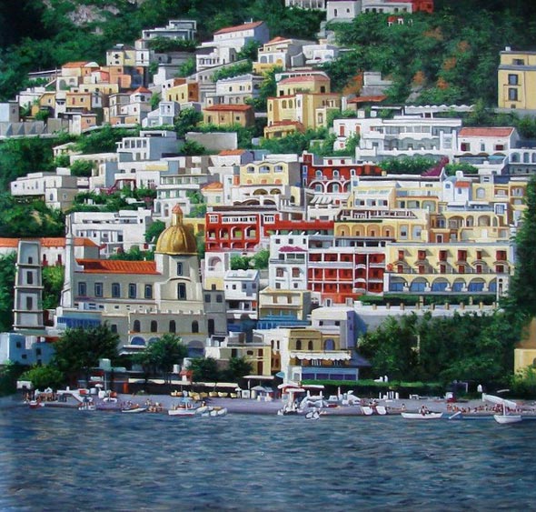 Coastal town with colorful buildings on a hillside, boats in the harbor.