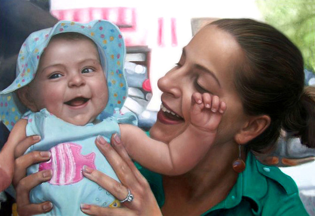 Smiling mother holding and interacting with a laughing baby wearing a sunhat.