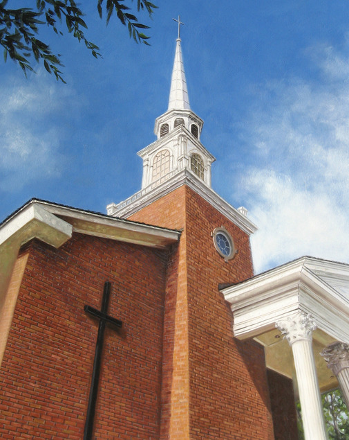 Brick church with steeple and cross under blue sky.