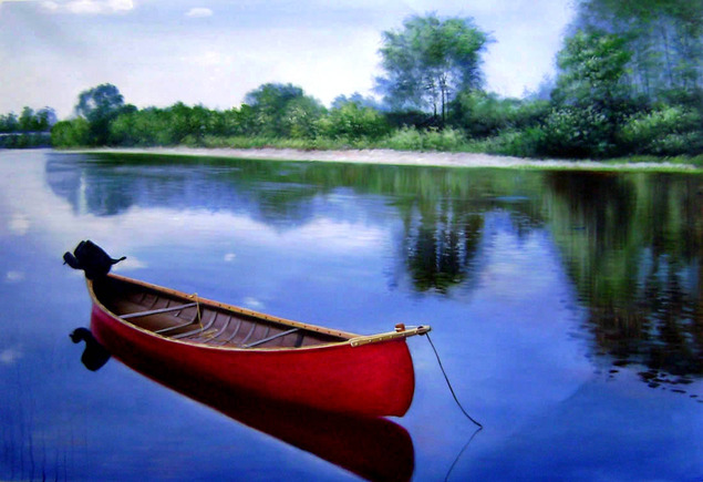 Red canoe on calm blue water, trees reflected in the water.