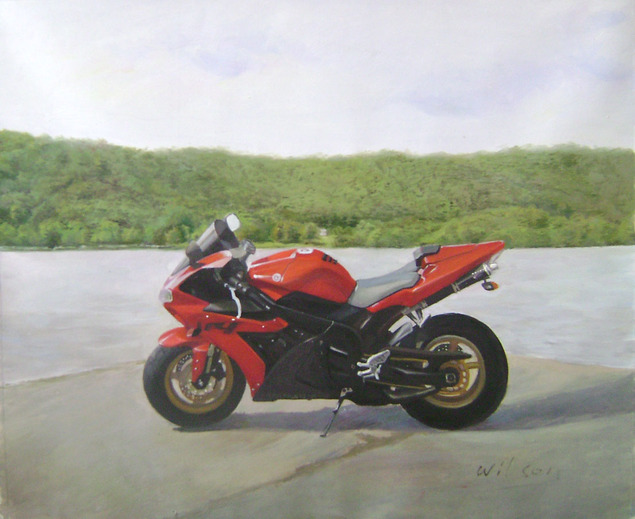 Red motorcycle parked by a lake with green hills in the background.