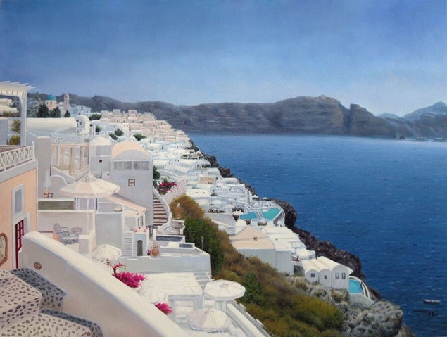 Coastal village of white buildings on a cliff overlooking the ocean.